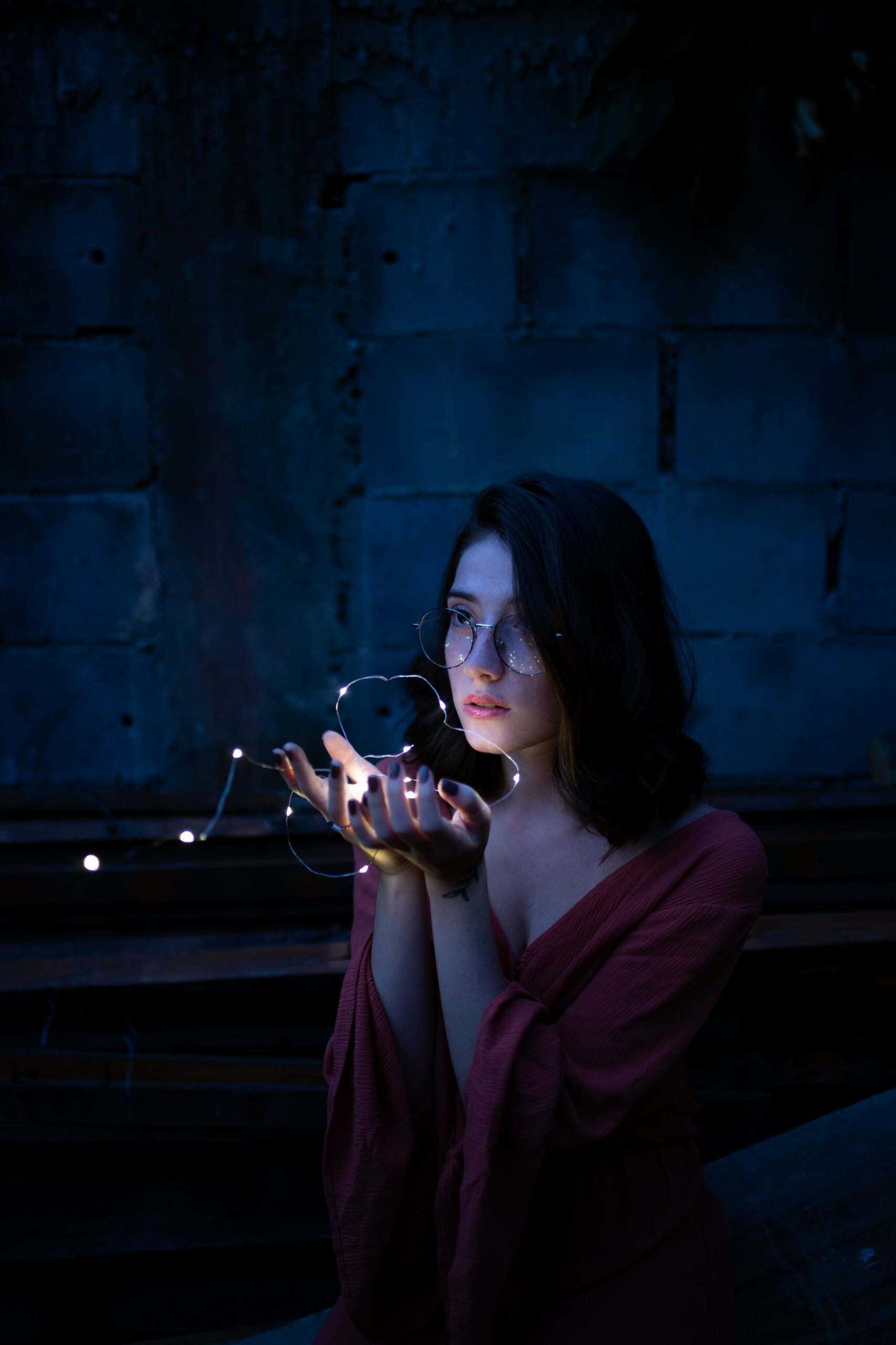 Woman Wearing Red Dress Holding Turned-on String Lights
