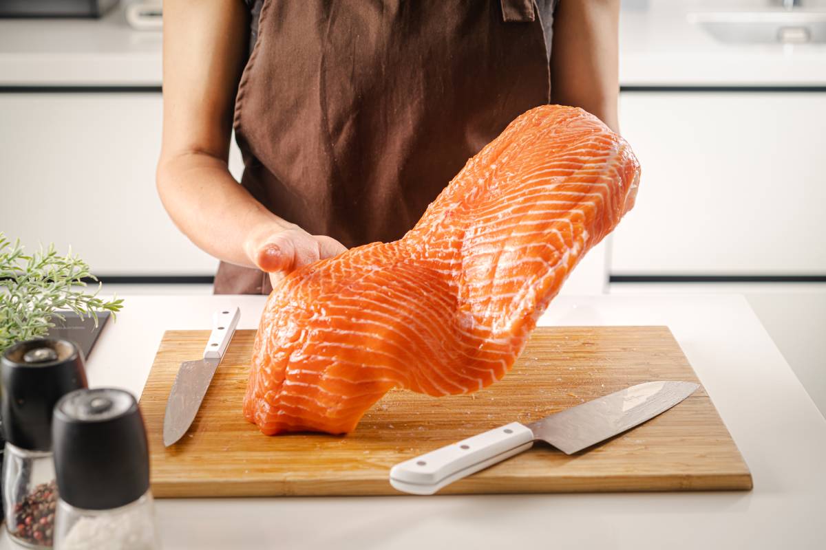 Women hold a raw salmon fillet